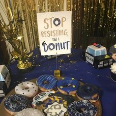 a table topped with lots of donuts covered in frosting and sprinkles