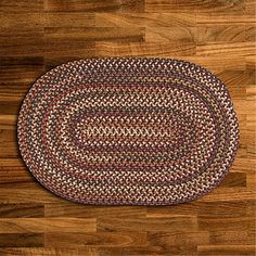 an oval rug on the floor with wood floors in the background and a wooden floor