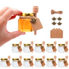 a hand is holding a jar with honey in it and several tags attached to the jars