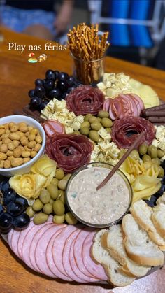 a platter filled with meats, olives, bread and other food items