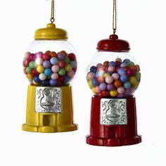 two gumball machines are hanging from chains