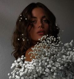 a woman holding a bouquet of white flowers