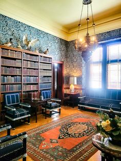 a living room filled with lots of furniture and bookshelves next to a window