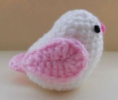 a small crocheted bird sitting on top of a table