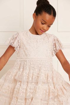 Description and Details The Angelica Lace KIDS in Cream. This elegant dress is designed with intricate embroidery, inspired by Victorian lace trims. Tiered frills add a playful and charming quality to this timeless design. The ultimate addition to your little one's wardrobe. - Tulle decorated all-over with tonal embroidery - 100% Polyester - Fully lined - Grosgrain ribbon trim around waistline - Tulle frill detail around waistline - Concealed zip at centre back - Made in India Care Advice - Deli First Communion Spring Dress With Lace Trim, Spring First Communion Dress With Lace Patchwork, First Communion Spring Dress With Lace Patchwork, First Communion Lace Patchwork Dress For Spring, Elegant Lace Dress With Ruffles For Dress-up, Spring Confirmation Lace Dress, Cream Dress With Ruffles For First Communion, Party Dress With Flutter Sleeves And Lace Trim, Spring Lace Dress For First Communion