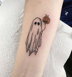 a small ghost with a pumpkin tattoo on the arm