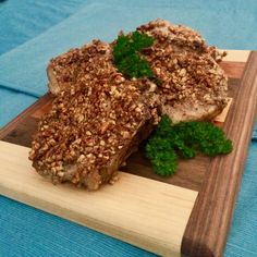 two pieces of food sitting on top of a wooden cutting board next to parsley