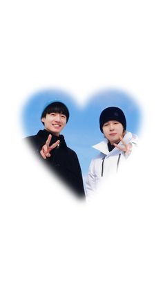 two young men standing next to each other in front of a heart shaped photo frame