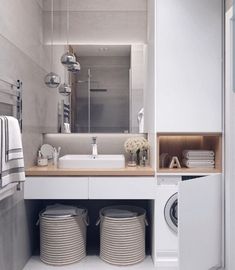 a washer and dryer in a small bathroom with white walls, flooring and cabinets