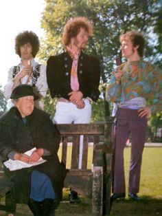 four people sitting on a bench in the park