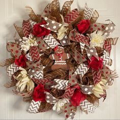 a wreath made out of burlocks and fabric with flowers on the front door