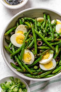 a bowl filled with green beans and hard boiled eggs