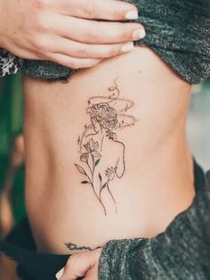 a woman with a flower tattoo on her stomach