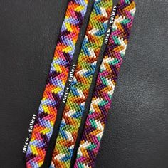 two multicolored bracelets on a black surface