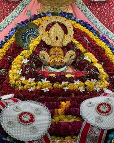 an elaborately decorated statue in the center of a room with flowers and other decorations