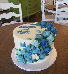 a white and blue cake sitting on top of a wooden table