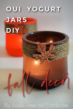 an orange candle is sitting next to a jar with a leaf on it and the words, oui yogurt jars diy fall decor