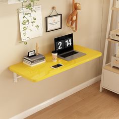 a laptop computer sitting on top of a yellow desk