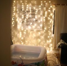 a baby's bathtub with lights on the wall and a quote above it