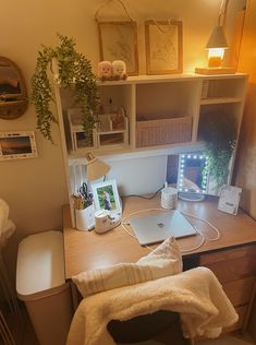 a laptop computer sitting on top of a wooden desk next to a lamp and chair