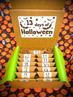 an open box filled with lots of halloween themed numbers and candy boxes on top of a table