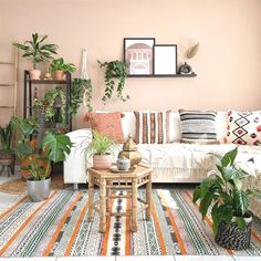 a living room filled with lots of different types of furniture and plants on top of rugs