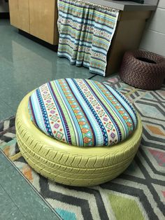 a yellow tire ottoman sitting on top of a rug