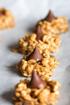 chocolate covered cookies are lined up on a piece of parchment paper with other pieces in the background