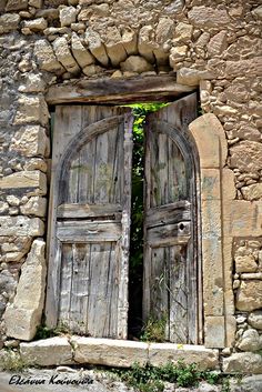 an old stone building with two wooden doors