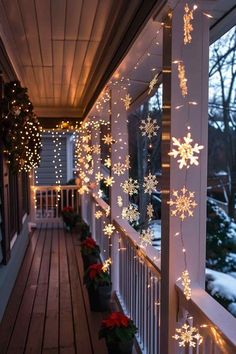 snowflake lights are hanging from the side of a porch