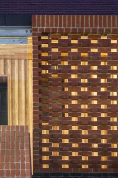 the side of a brick building with wooden slats on it's front door