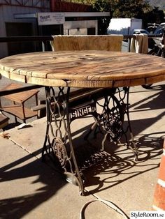 an old sewing table is sitting on the sidewalk