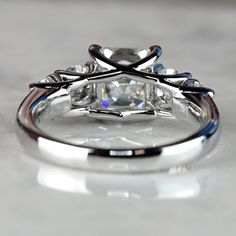 a close up view of an engagement ring with a diamond in the center and two side stones on each side