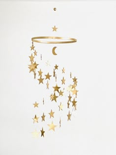 a mobile with stars and a crescent hanging from it's side on a white wall