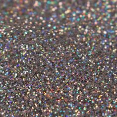 multicolored speckles are scattered on top of a black surface in this close up photo