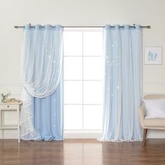 a living room filled with furniture and a window covered in blue drapes next to a white chair