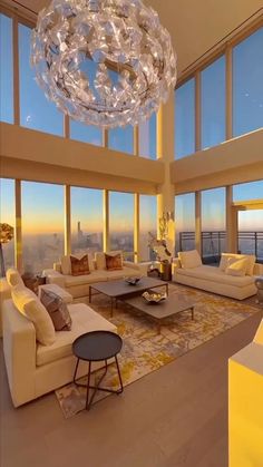 a living room filled with lots of furniture and large windows overlooking the cityscape