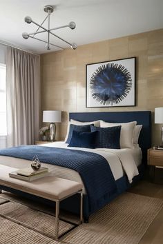 a bedroom with blue and white bedding, beige walls and lamps on either side of the bed