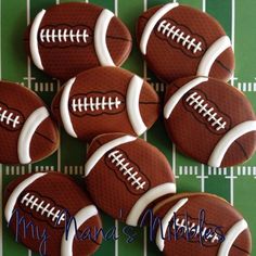 chocolate football cookies with white frosting on a green tableclothed surface, ready to be eaten