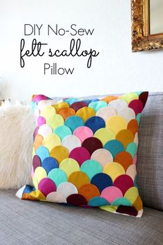 the diy no sew felt scallop pillow is sitting on a couch