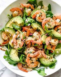 shrimp and avocado salad in a white bowl on a marble countertop, ready to be eaten