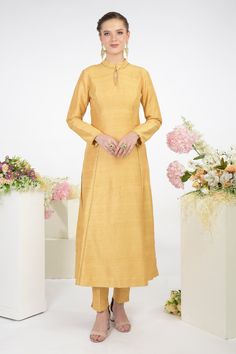 Gold kurta highlighted with delicate embroidery, keyhole mandarin collar, full sleeves and A-line silhouette. Comes with pant.
Components:2
Embroidered
Neckline:Mandarin Collar
Sleeve Length:Full
Fabric:Raw Silk
Color:Gold
Princess A-Line cut
Keyhole neckline with loop placket
Concealed zip at the side - Aza Fashions Raw Silk Kurta, Plain Dresses, Silk Kurta Set, A Line Kurta, Silk Kurta, Indian Bridal Wear, Plain Dress, Embroidered Neckline, Gold Silk