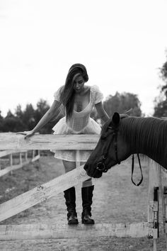 a woman is standing next to a horse