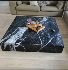 a black marble coffee table with sushi on it