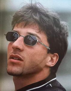 a close up of a person wearing sunglasses and looking off to the side with a serious look on his face