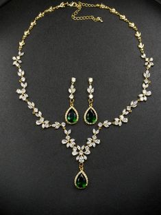 a necklace and earring set with green stones