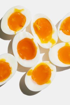 an overhead view of hard boiled eggs on a white surface