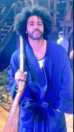 a man with an afro holding a baseball bat and wearing a blue bathrobe