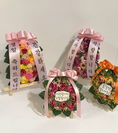 three small baskets with flowers and ribbons tied around them, each containing a happy birthday message