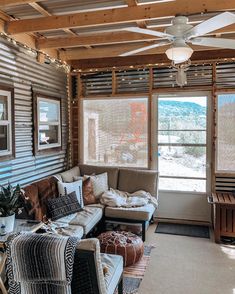 a living room filled with furniture and windows covered in light wood slatted coverings